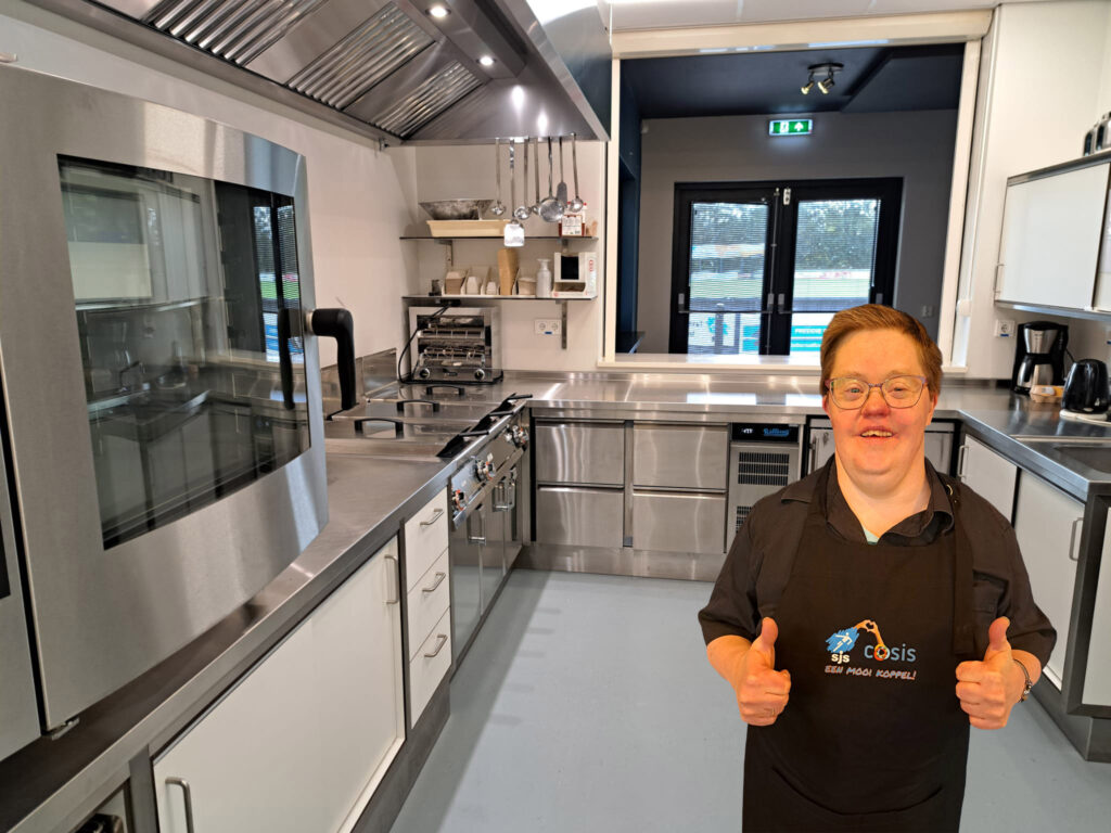 Cliënt Cosis staat blij in de nieuwe keuken van voetbalvereniging SJS.